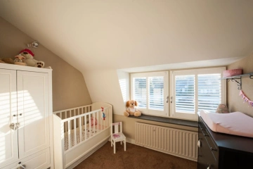 Witte shutters voor draairaam in babykamer