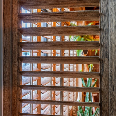 Bruine houtkleurige shutters met bedieningsstokje