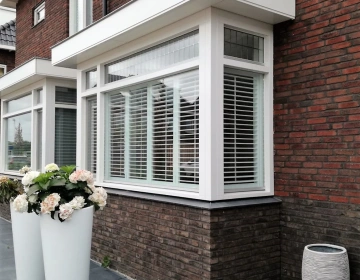 Buitenaanzicht nieuwbouwwoning met witte shutters