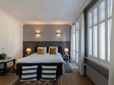 Karakteristieke witte shutters in een slaapkamer
