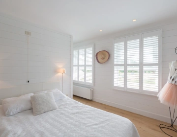 Shutters blancs sur chambre lumineuse