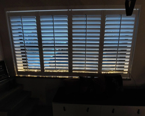 Witte-shutters-met-kerstverlichting-in-raamkozijn.jpg