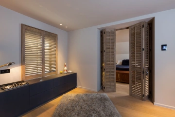 Slaapkamer met houten shutters als roomdivider