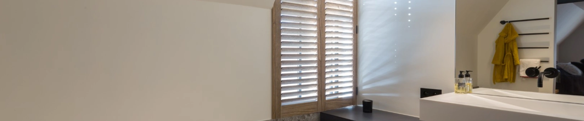 Shutters in beitskleur in de badkamer