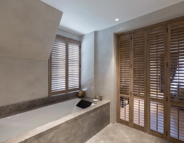 Shutters als roomdivider in badkamer