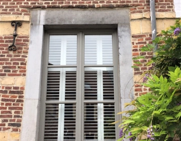 Buitenkant groot raam met houten shutters