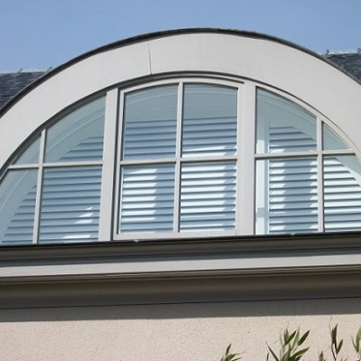 Halfrond raam met witte shutters