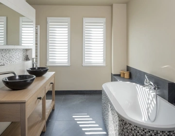 Fenêtres dans la salle de bain avec shutters blancs