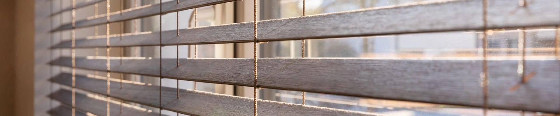 Bruine houten jaloezieën voor het raam