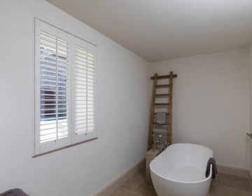 witte shutters met houtnerf in de badkamer