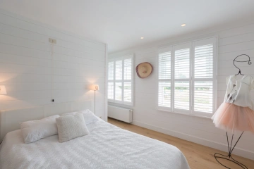 Lichte slaapkamer met witte shutters
