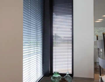 Zwarte blinds voor hoge ramen in woonkamer