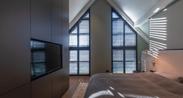 Stijlvolle shutters in driehoek in slaapkamer