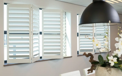 Witte verstelbare shutters in kantoorruimte