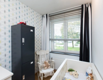 Babykamer met stijlvolle lichte jaloezieën