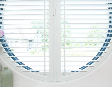 Rond raam in badkamer met shutters als raamdecoratie