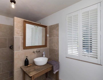 Salle de bain champêtre aux shutters blancs