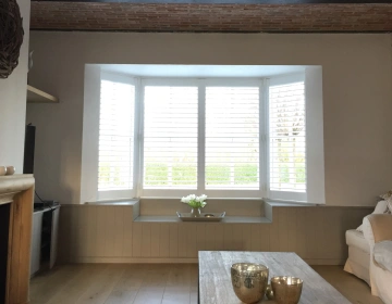 Witte shutters in erker