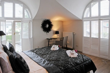 Witte shutters in toograam van slaapkamer