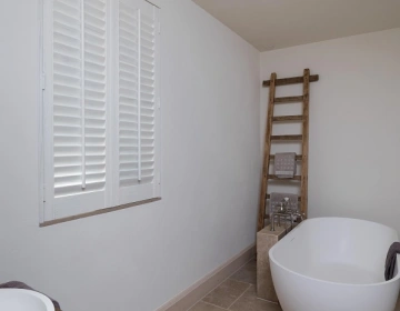 Shutters blancs dans une salle de bain lumineuse