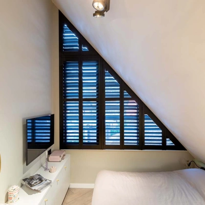 Slaapkamer met schuin raam en shutters
