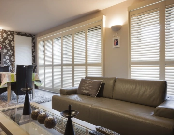 Witte shutters op schuifrail in woonkamer