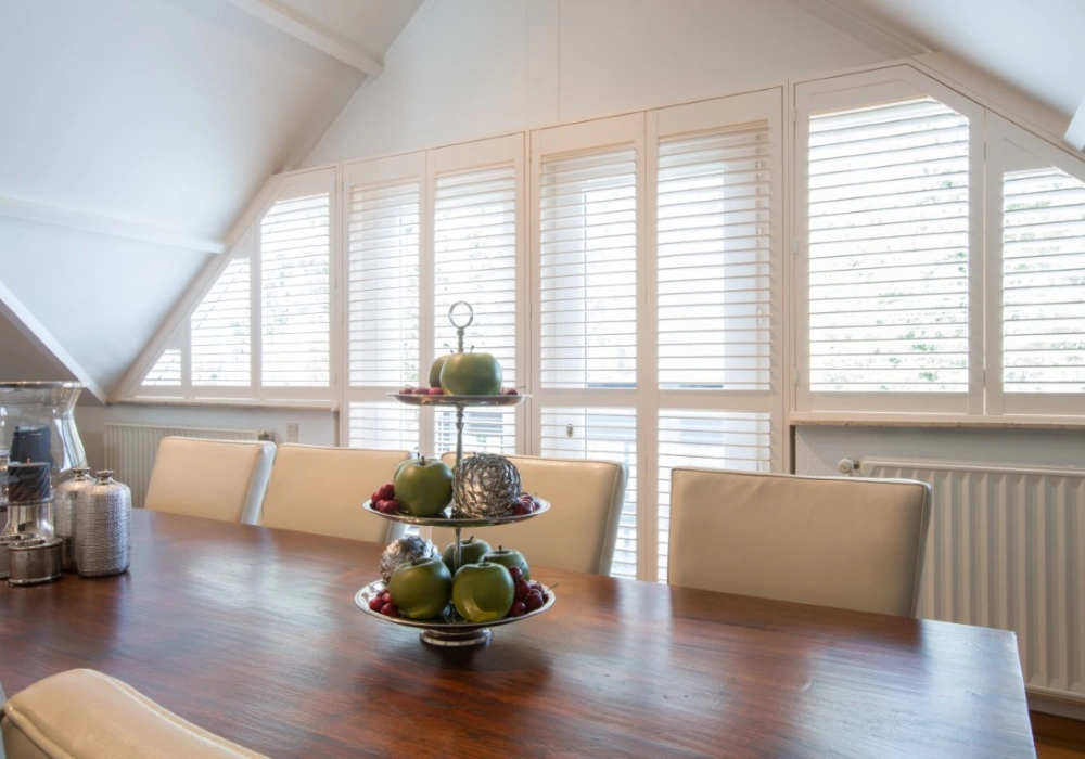 witte houten shutters in schuine ramen