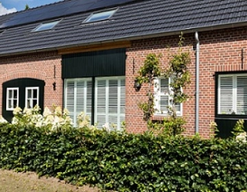 Buitenaanzicht boerderij met witte shutters