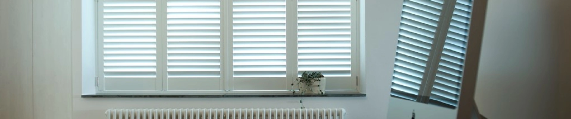 Witte shutters als raamdecoratie in werkruimte
