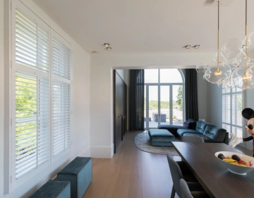 Witte shutters als zonwering in woonkamer