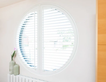 Shutters voor een rond raam in de badkamer