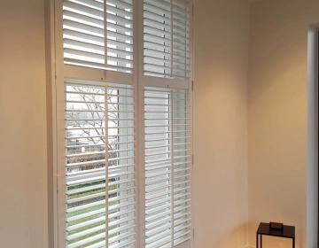 Witte shutters met tilt rod in woonkamer