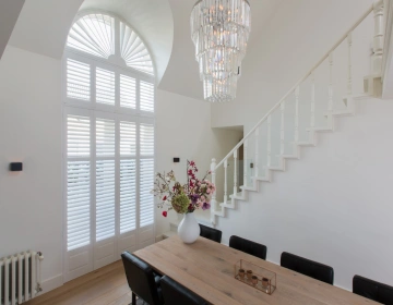 sunburst shutters voor toograam in woonkamer