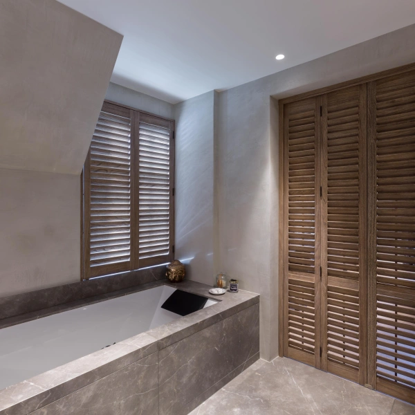 Shutters als roomdivider in de badkamer