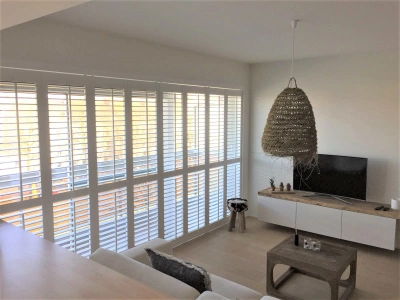 Groot raam met witte shutters in woonkamer