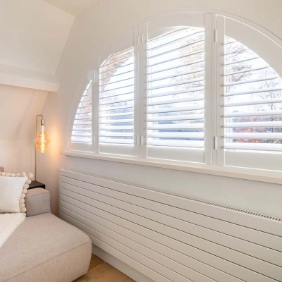 Halfrond raam met witte shutterluiken