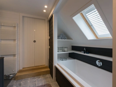 Witte shutters op dakraam in badkamer