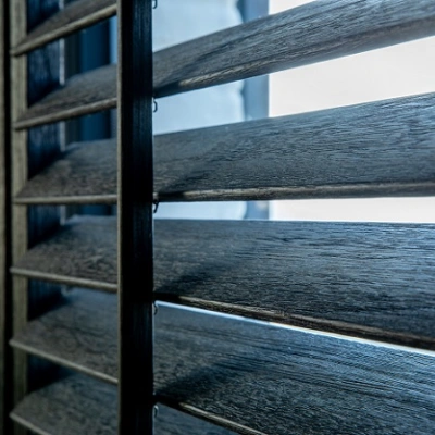 Zichtbare houtnerf in zwarte shutters met tilt rod