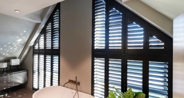 Zwarte shutters in groot schuin raam